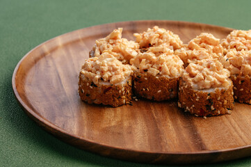 Sushi and soy sauce in a bowl and wooden chopsticks on a gray wooden table. Japanese food. 