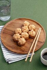 Sushi and soy sauce in a bowl and wooden chopsticks on a gray wooden table. Japanese food. 