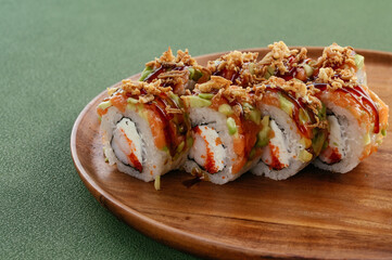 Sushi and soy sauce in a bowl and wooden chopsticks on a gray wooden table. Japanese food. 