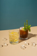 Alcoholic cocktails and ice on colored backgrounds with hard shadows.