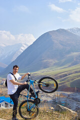 A tourist with a bicycle on the background of mountains