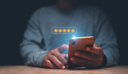 Businessman using smartphone to give five-star symbol for highest satisfaction, 5-star feedback, reputation and quality Concept of standardization and quality in products and services. - obrazy, fototapety, plakaty