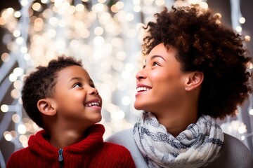 Afro American mother and boy casual portrait with bokeh lights as background. Christmas vibes shot