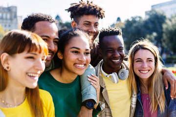 United group of multiracial young friends feeling positive standing together outdoors. Youth community, diversity and friendship concept