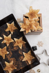 Cinnamon star sugar or short bread cookies.  Freshly baked cookies sprinkled, heavily with cinnamon and sugar.  Star shaped cookie cutter and textured baking pan.