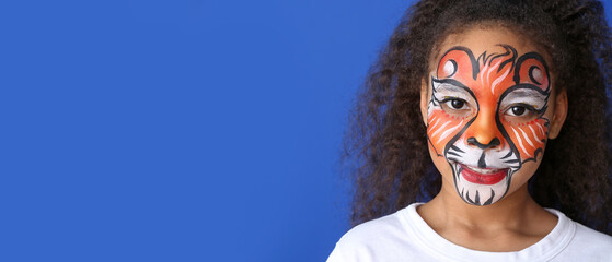 Funny African-American girl with face painting on blue background with space for text
