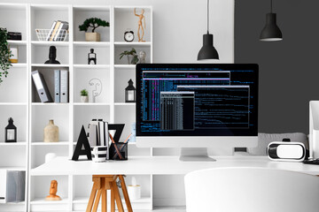 Computer monitor with programming code at workplace in office