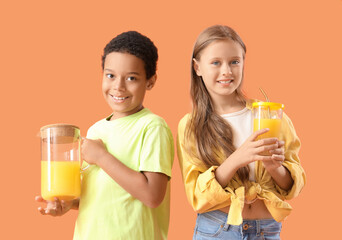 Little children with cup and jug of fresh citrus juice on orange background