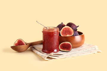 Jar of sweet fig jam on yellow background