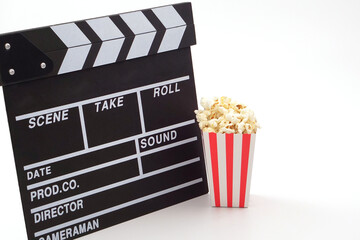 Clapperboard or movie slate black color with popcorn on white background. Cinema industry, video...