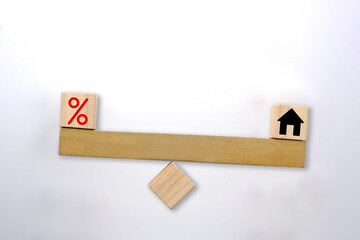Percentage icon and house on an unbalance seesaw. Interest rate finance, real estate and house loan concept.