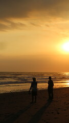 Fototapeta na wymiar sunset on the beach in Bali, the woman talking with fisherman