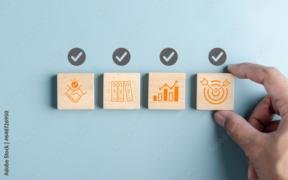 Poster Hand holding wooden block with Quality Assurance or QA and Quality Control or QC and improvement. Standardization, certification. Compliance to regulations service and standards...