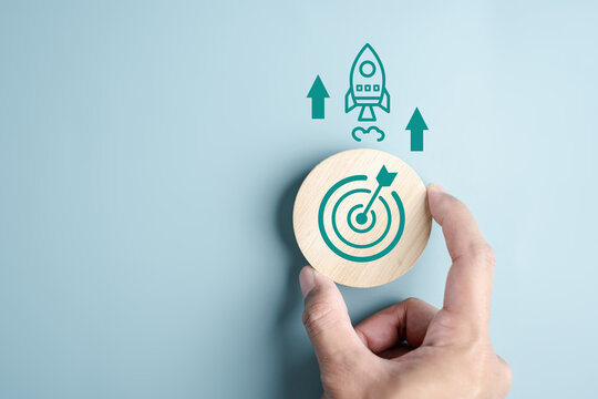 Hand holding objective aiming target and rocket ship launch arrow up to leadership and customer target group for start business to goal achievement.
