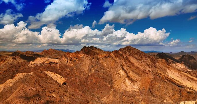 Rising above the rocks of Mojave desert. Amazing bright azure sky with white cotton clouds at backdrop.