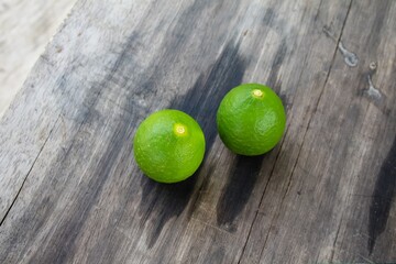 two green limes on wooden background
