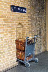 Fototapeta premium London, United Kingdom - 27 July 2016: Platform 9 3/4 photo spot at King's Cross station. Tourists can post photos with the trolley which stuck in the wall