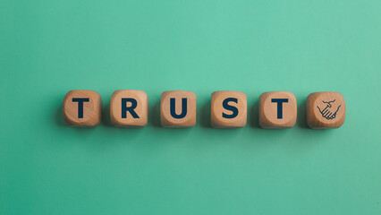 Wooden blocks with the word Trust. Trust relationships between business partners, friends, and relatives. Respect and authority. Confidence in a person. Reliable partner