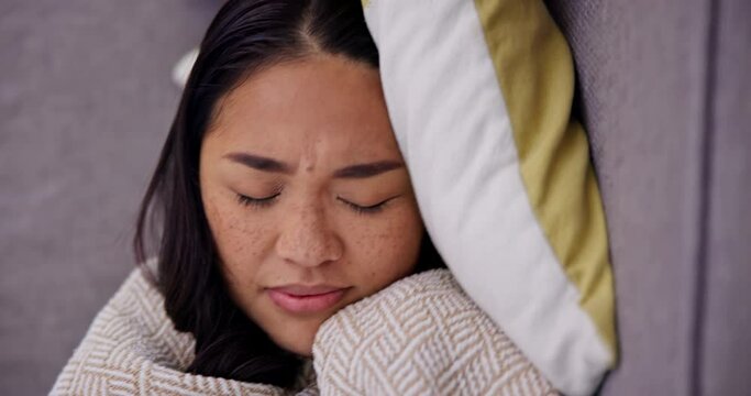 Woman sleeping on sofa, tired and fall down to relax in home living room, exhausted and bored. Depression, rest on couch and fatigue with face of person in lounge with dreaming, lazy and snooze