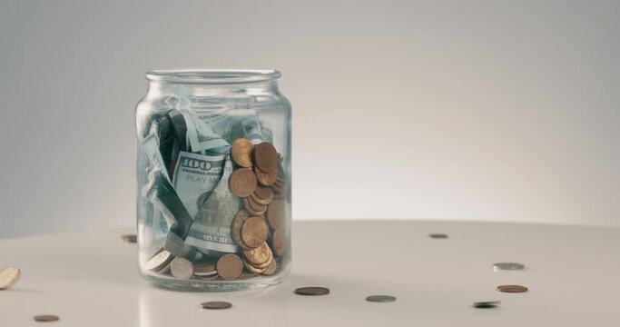 Money, savings and a glass jar for budget on a table for finance, wealth on investment in the future. Retirement, economy and coin banking with a container for growth or store profit change or income