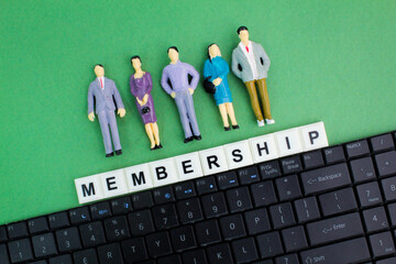 laptop keyboard and miniature people with the word membership alphabet letters. the concept of...
