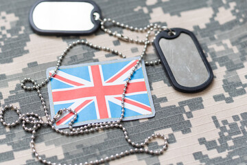 army blank, dog tag with flag of great britain on the khaki texture background. military concept