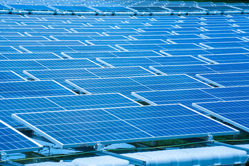 Side view of solar panels floating on water in a lake, for generating electricity from sunlight, selective focus, soft focus.