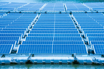 Side view of solar panels floating on water in a lake, for generating electricity from sunlight, selective focus, soft focus.