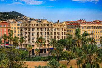 Aerial view of Old Town or Vielle Ville buildings, the trees of Promenade du Paillon and Castle Hill or Colline du Chateau at sunset in Nice, France