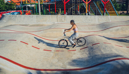 Happy young woman enjoy BMX riding at the skatepark