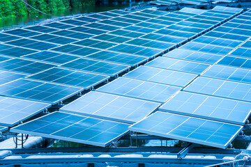 Side view of solar panels floating on water in a lake, for generating electricity from sunlight, selective focus, soft focus.