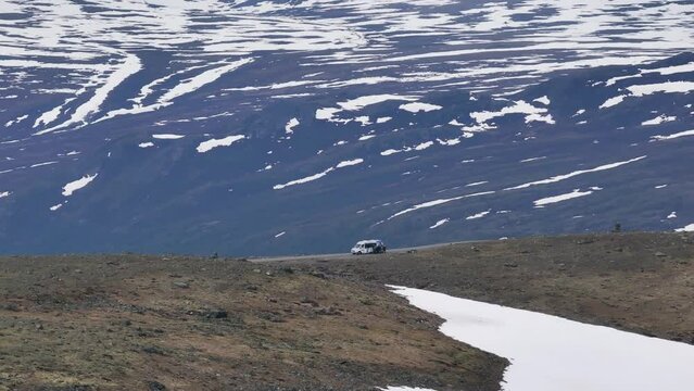 Epic view of a shuttle bus and tourists on the scenic road to Galdh&oslash;piggen mountain in Norway