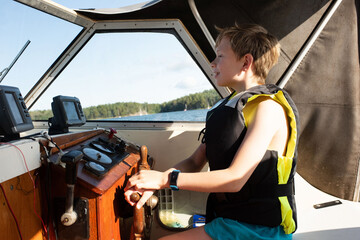 boy happily driving a motorboat out at sea