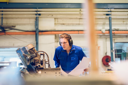 Serious man in headset near welding machine