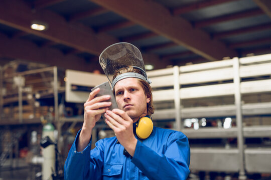 Focused worker examining machine part in factory