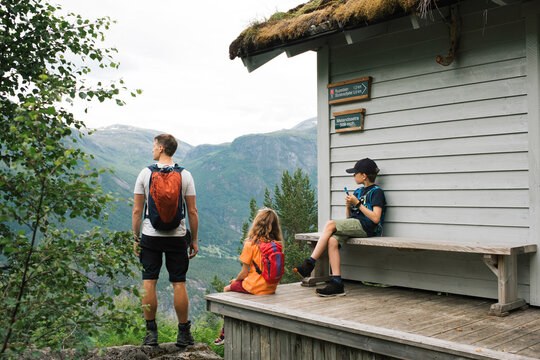 family taking a break whilst hiking up a mountain in Norway
