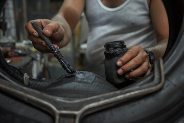 hands of man close up vulcanize a tire to repair it