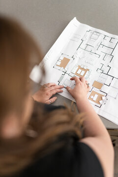 An interior designer arranging furniture for a house plan