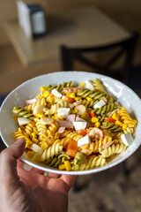 Vegetarian fusilli pasta salad with tomato herbs, cheese and crab sticks