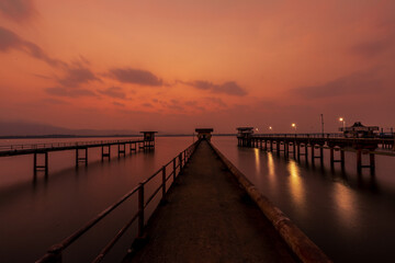 Obraz premium The background of the sea by the evening sea, with natural beauty (sea water, rocks, sky) and fishermen are fishing by the river bank, is a pleasure during travel.