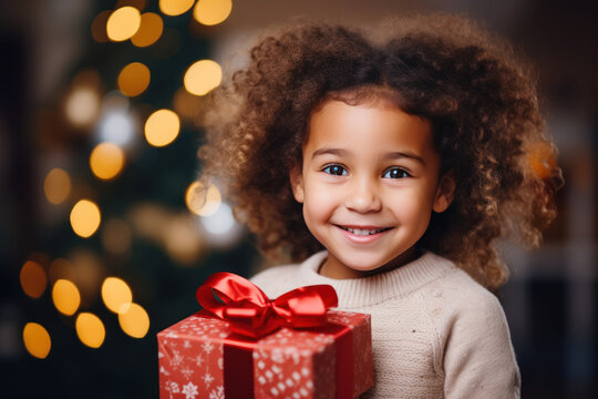 African girl smile shaking christmas present, happy child gets gift