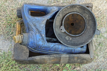 two cut plastic in oil discarded used empty dirty blue and black canisters along with black plastic watering cans lie on the ground on the street during the day