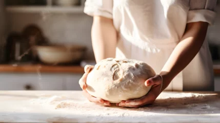Photo sur Plexiglas Pain Close up of a white caucasian woman's hands preparing dough to make bread in a home kitchen 