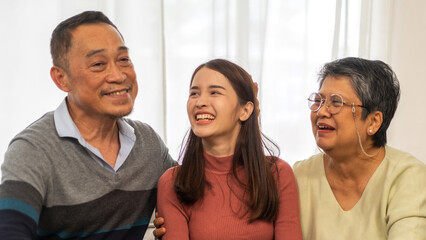 Fototapeta premium Portrait enjoy happy smiling love asian family.Senior mature father hug with elderly mother and young adult woman play laughing and having fun together at home.insurance concept