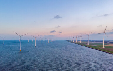 Sunset at Windmill Park in the ocean aerial view with wind turbine Flevoland Netherlands Ijsselmeer. Green Energy Production in the Netherlands