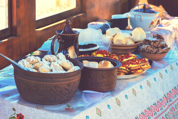 Dumplings with sour cream in a clay plate on the table. Ukrainian folk cuisine.