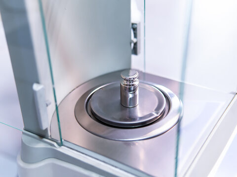 Close-up of metal weight to calibrate on a balance in a laboratory.