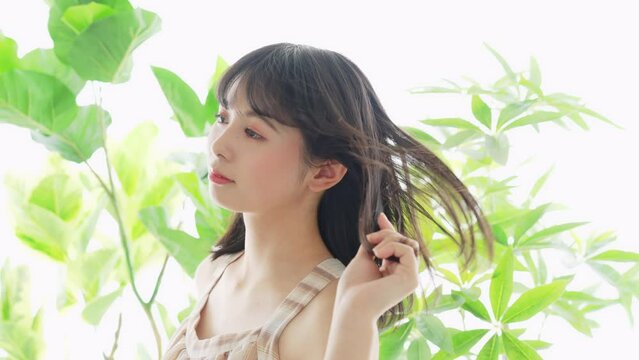 緑に囲まれた女性　ボタニカルな美容イメージ