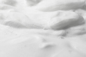 Foam as background, closeup. Face cleanser, skin care cosmetic