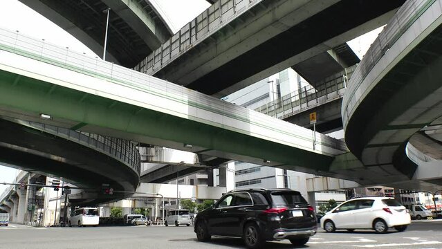 OSAKA, JAPAN - JULY 2023 : View of Awaza junction. Time lapse shot in daytime. Japanese traffic, transportation and road concept video. Low angle shot.